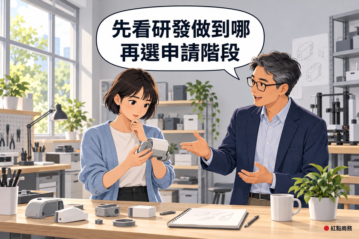 明亮的小型產品實驗室,穿霧藍色開襟衫、短鮑伯頭的女工程師站在木製工作台前拿著一個灰白零件組成的半成品原型,旁邊戴眼鏡、灰白短髮、穿靛藍色西裝外套的男補助顧問攤開一手指向原型,桌上有零件、只有鉛筆線條的素描本、馬克杯和一盆綠色植物,對話氣泡寫著先看研發做到哪再選申請階段